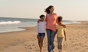 Mother and Children Walking on Beach